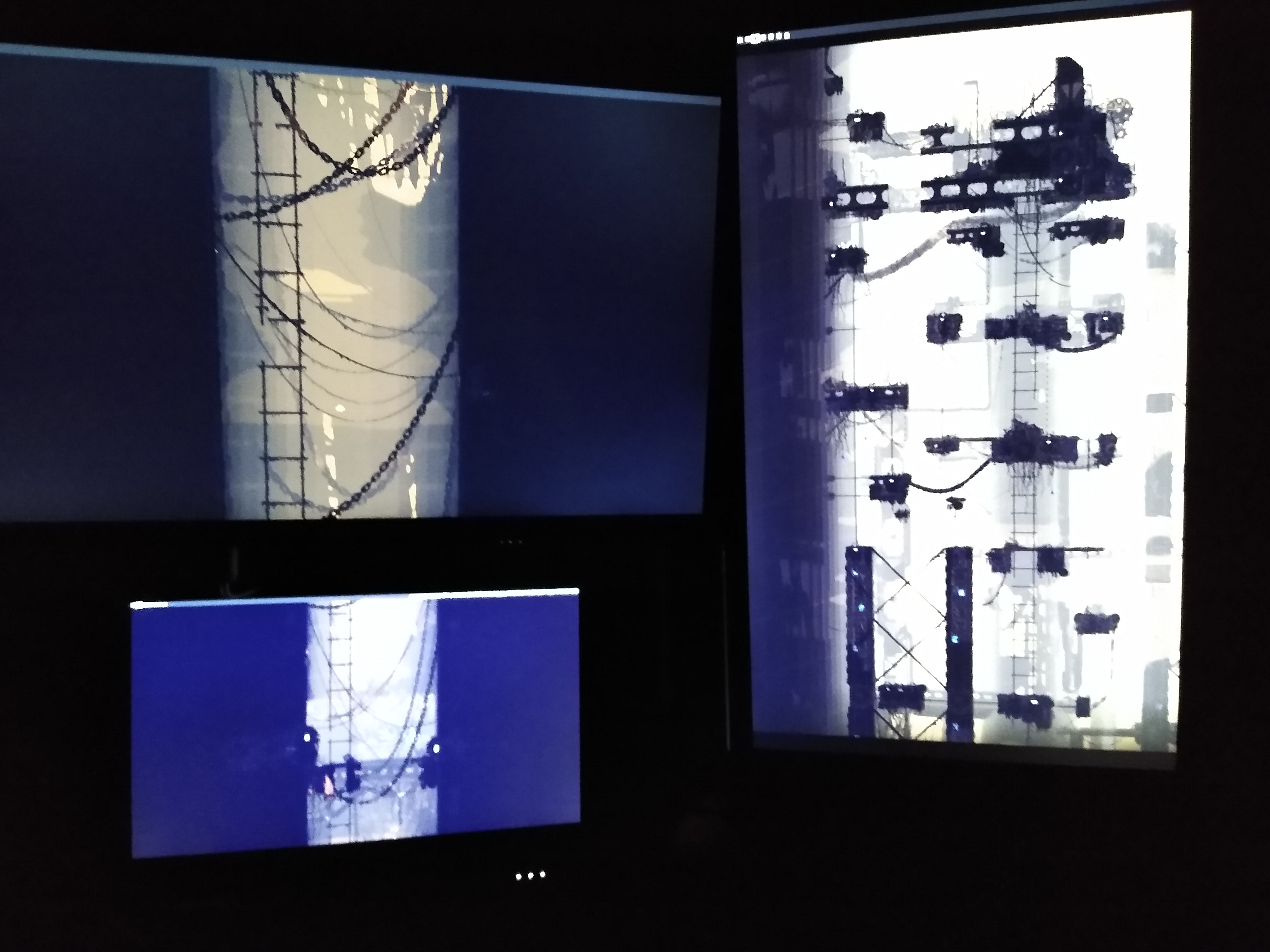 A picture of a computer setup. There are multiple monitors each only displaying a wallpaper, which is stretched across all of the monitors.