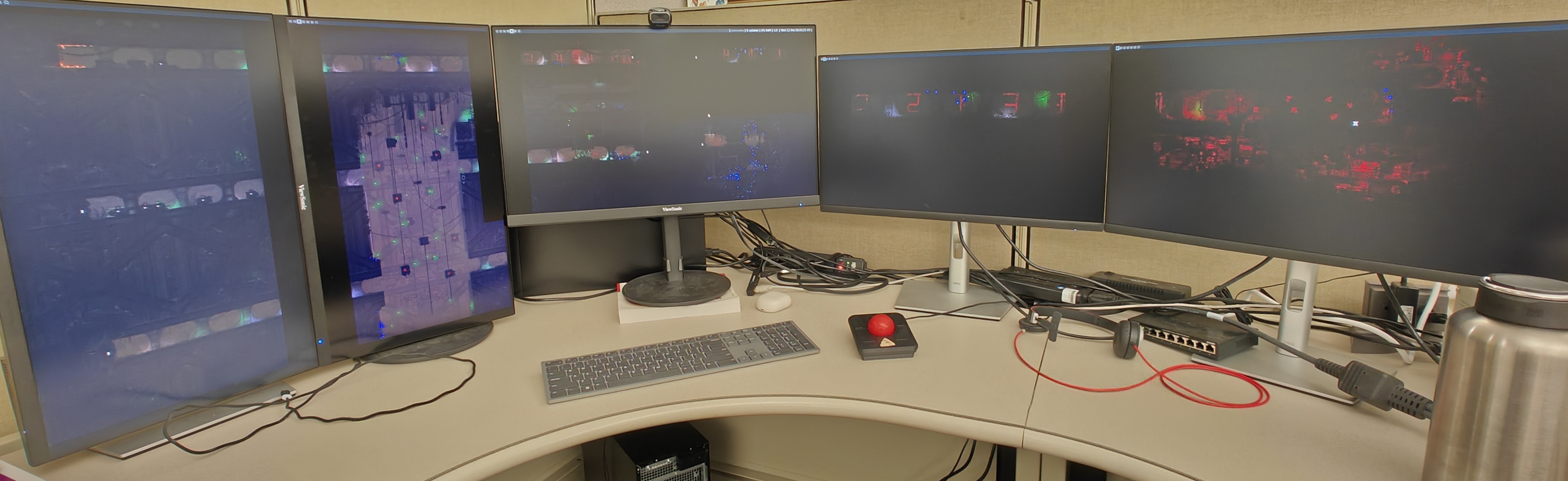 A picture of a computer setup. There are multiple monitors each only displaying a wallpaper, which is stretched across all of the monitors.