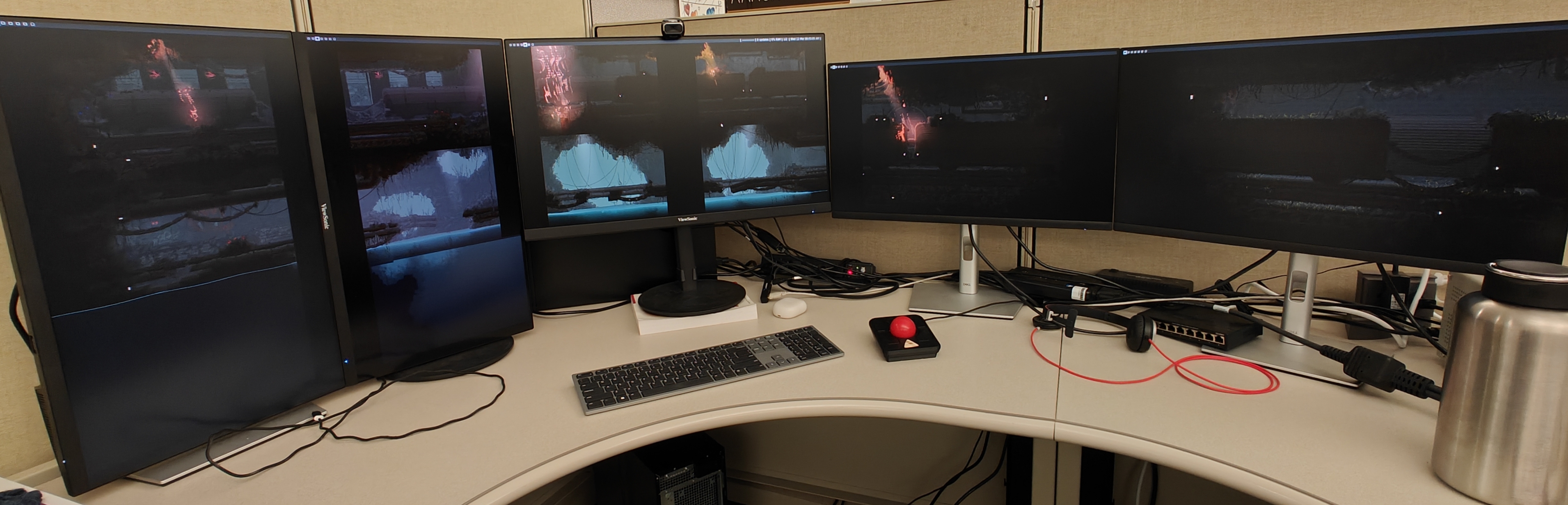 A picture of a computer setup. There are multiple monitors each only displaying a wallpaper, which is stretched across all of the monitors.