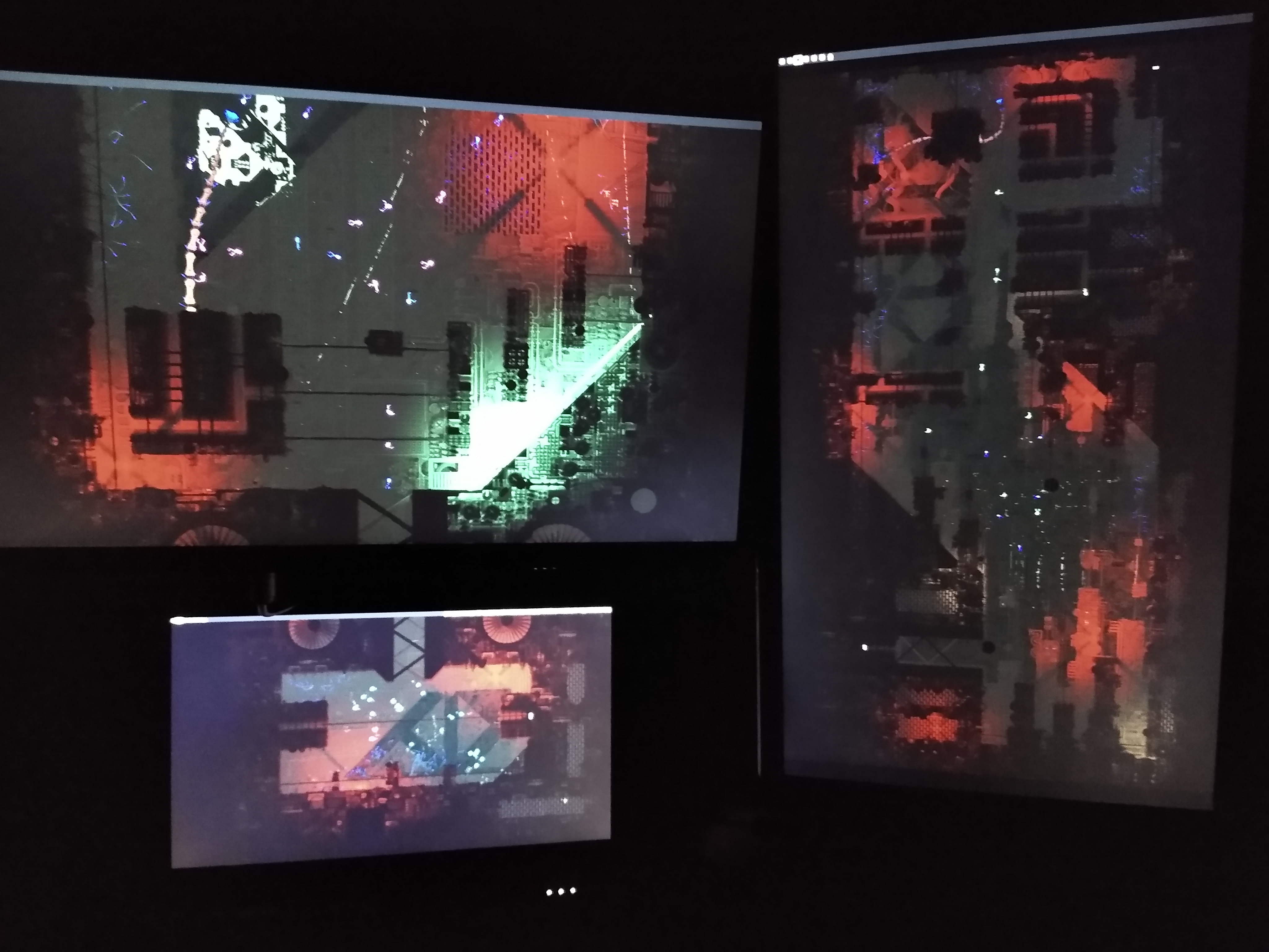 A picture of a computer setup. There are multiple monitors each only displaying a wallpaper, which is stretched across all of the monitors.